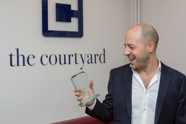Marcos White, owner of The Courtyard holding the award for completing 500 Invisalign cases